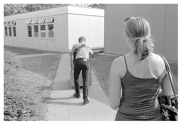Strasser schiebt einen schweren Wagen. Kathrin verwaltet die durcheinander gew&uuml;rfelten Klassen. Foto: ich. 2003.